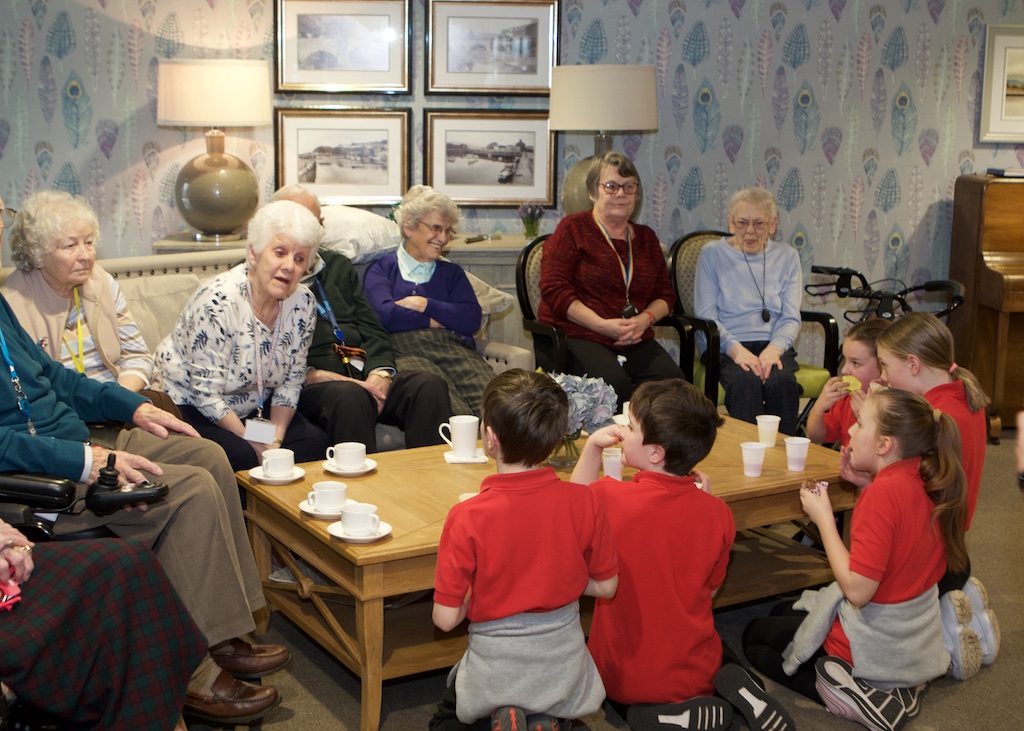 Hafod y Gest residents in the communal area chatting with local school children